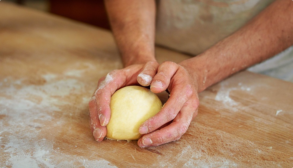 Photo de mains pétrissant la pâte